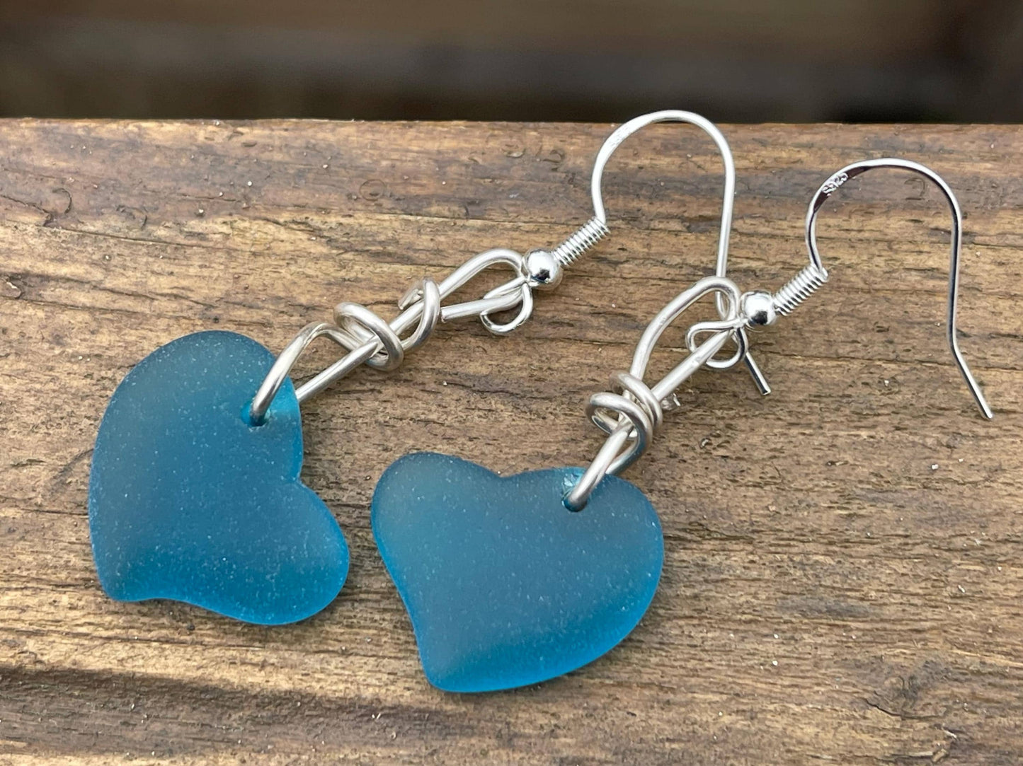 Sea glass heart earrings iron recycled sterling silver. Eco conscious jewellery. Ethical jewellery. Blue sea glass hearts. Handmade earrings