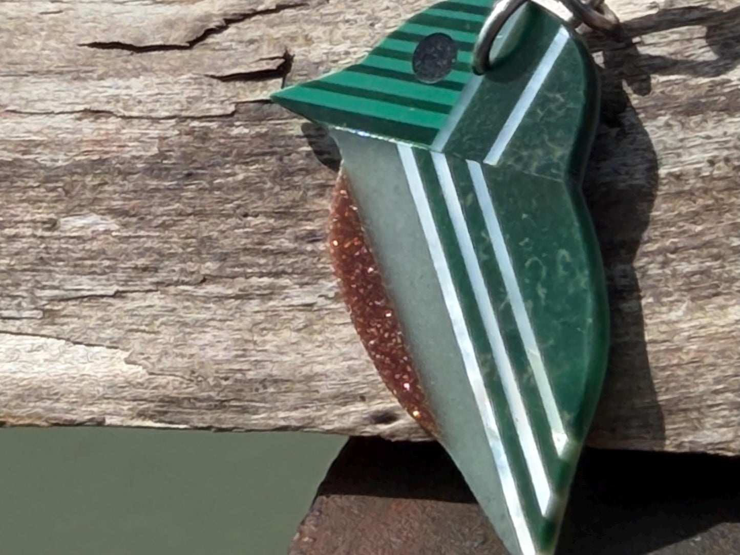 Kingfisher necklace showcasing strips of malachite. Green kingfisher pendant wrapped in recycled sterling silver.