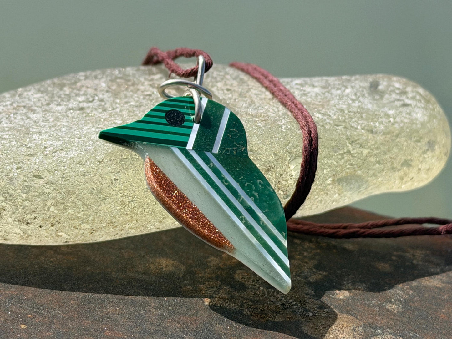 Kingfisher necklace showcasing strips of malachite. Green kingfisher pendant wrapped in recycled sterling silver.